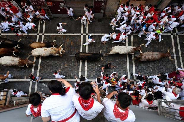  Participants run ahead of bulls during the "encierro" (bull-run) of the San Fermin festival in Pamplona