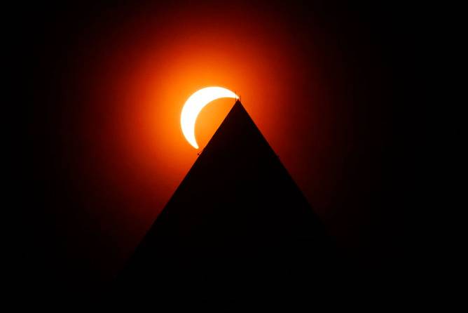 The solar eclipse is seen above the Washington Monument