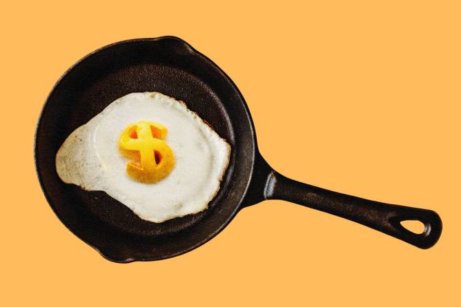 Fried egg in cast iron pan with dollar sign yolk.