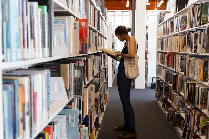 Woman reading a book at a library