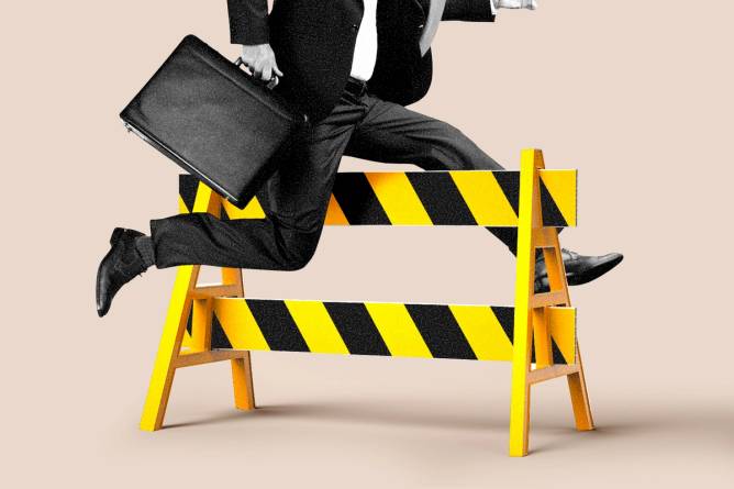 Person in business attire hurdling over a construction barricade