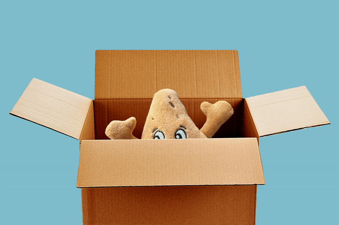 A Labubu, a Le Crueset Dutch Oven and a stuffed plushie pita chip coming out of the top of an open box.