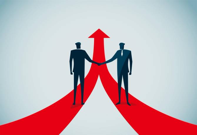 Two people shake hands while standing on red arrow