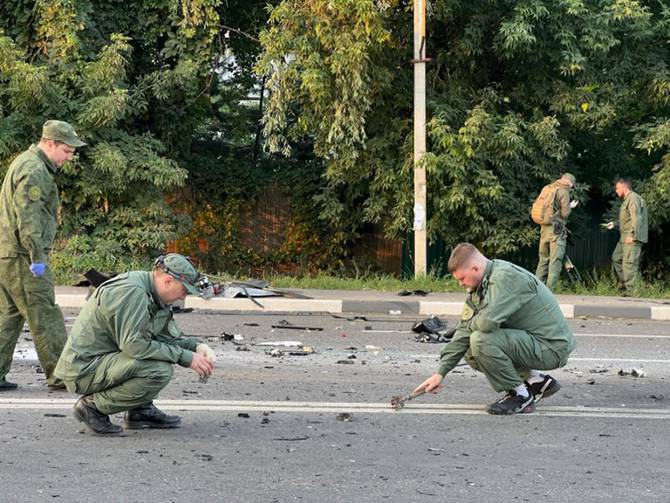 Russian officials investigate the scene after the car of Darya Dugina, daughter of Alexander Dugin, Russian political scientist and ally of President Vladimir Putin exploded on Mozhayskoye highway in Moscow.
