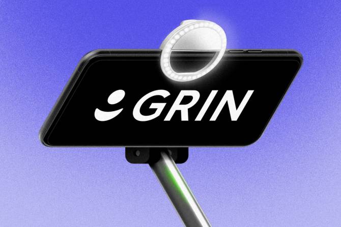Grin logo in a phone with a selfie stick and light