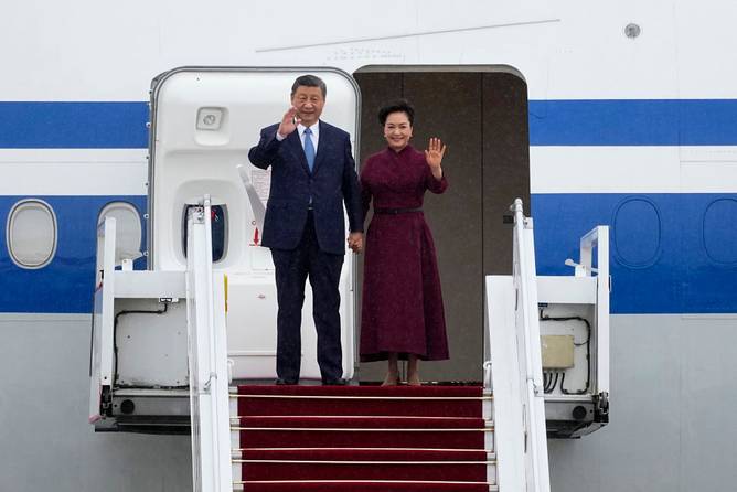 China's President Xi Jinping (L) and his wife Peng Liyuan wave upon their arrival for an official two-day state visit at Orly airport