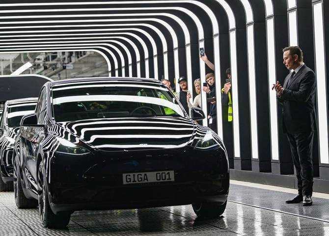 Tesla CEO Elon Musk looks at Tesla cars as he attends the start of the production at Tesla's 