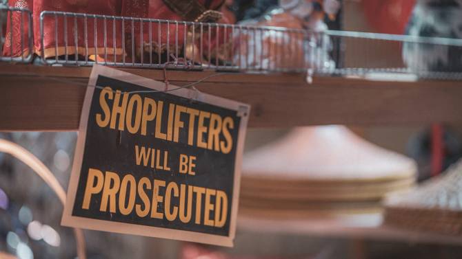 A sign in a store that says, "Shoplifters will be prosecuted."