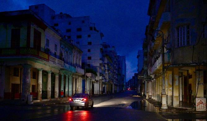 A car drives along a street during a nationwide blackout caused by a grid failure in Havana, on October 19, 2024