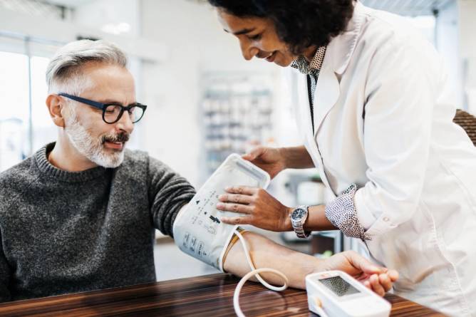 A pharmacist measures someone's blood pressure