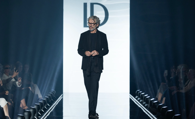 Lambert Wilson, playing fashion designer Vincent Ledu, appears on a runway in a still from the Apple TV+ original series 'Le Maison'