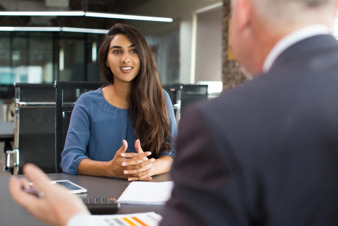 female talking to male behind desk
