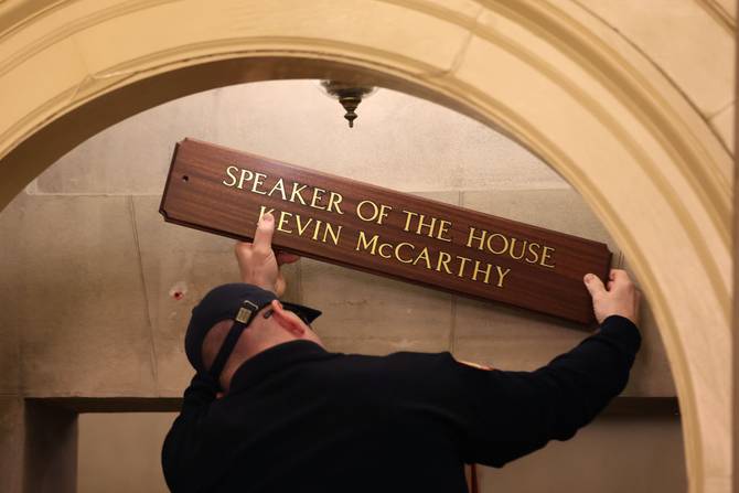 A worker replaces a sign over the office of U.S. Speaker of the House Kevin McCarthy (R-CA) after being elected as Speaker