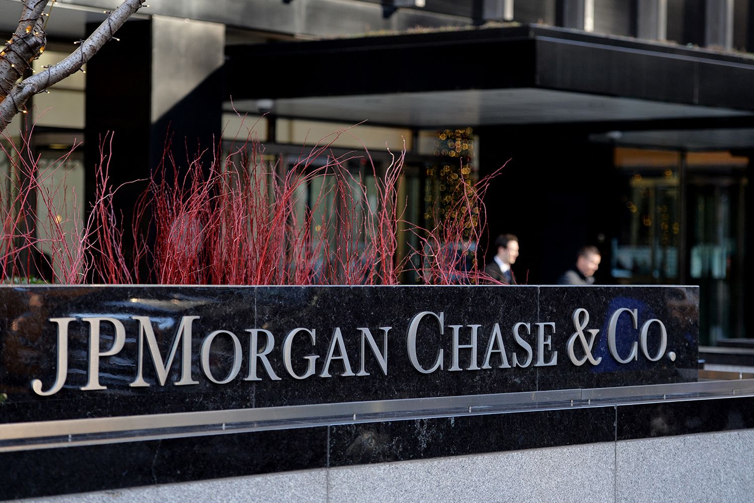 Two receptionists sit behind a marble counter that reads JP Morgan Chase & Co