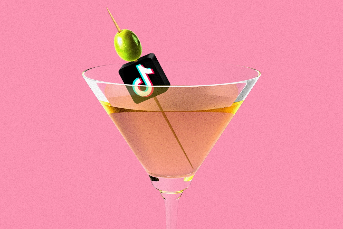 TikTok logo and olive skewed on a toothpick in martini glass.