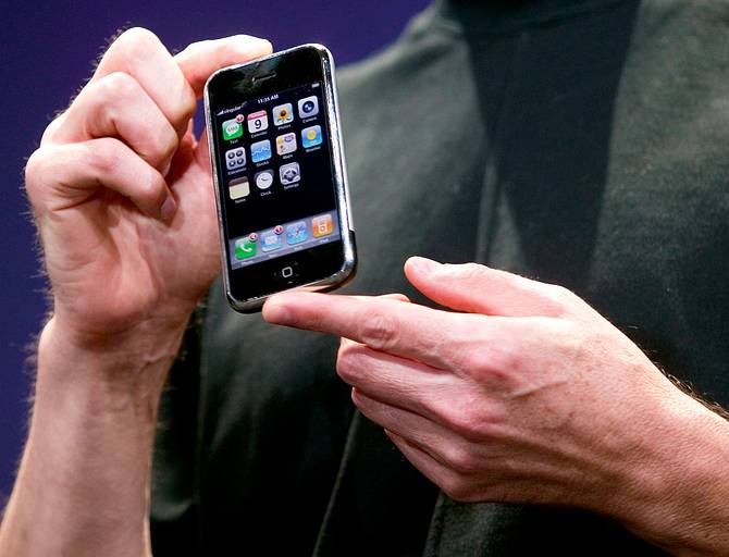 Steve Jobs's hands holding a first-gen iPhone