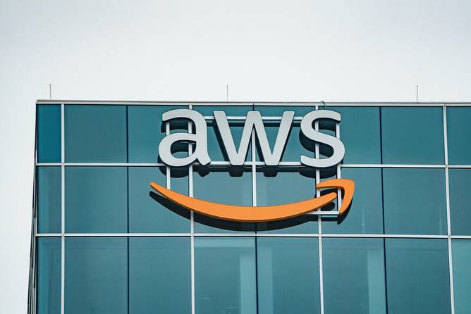 Logo of Amazon Web Services (AWS) on top of a glass building 
