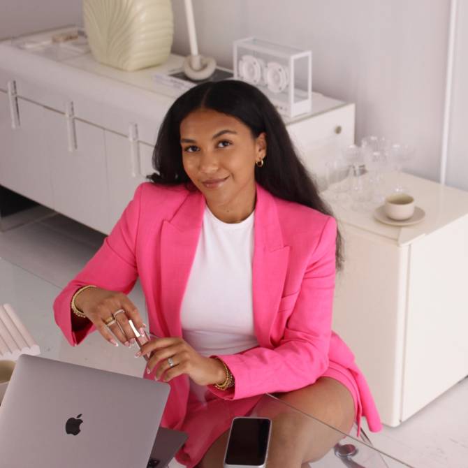 woman in pink suit with laptop computer