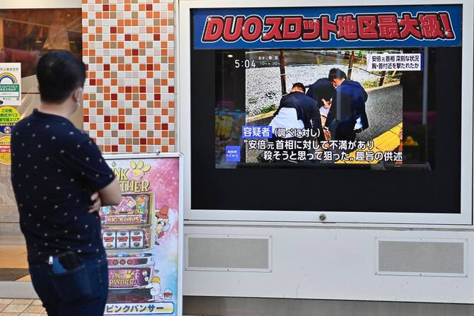 A man watches TV news information on the street about Shinzo Abe, Former Prime Minister of Japan, who was shot