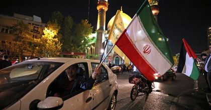 Demonstrators wave Iran and Palestinian flags on the streets of Tehran at night