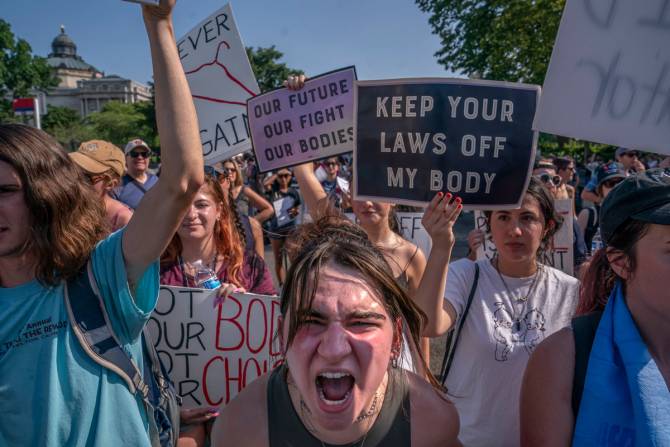 A woman screams into the camera at a march against overturning abortion rights.