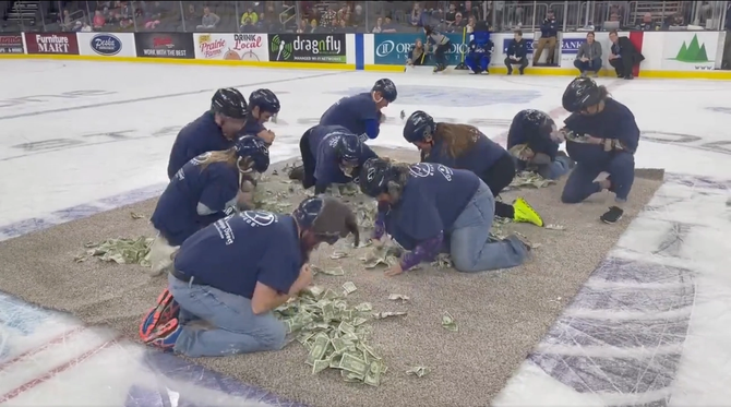 South Dakota teachers scramble for one dollar bills at a hockey game.