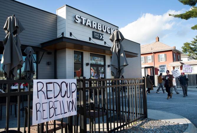 A grey Starbucks building is pictured with a sign that reads "REDCUP REBELLION" displayed in front.