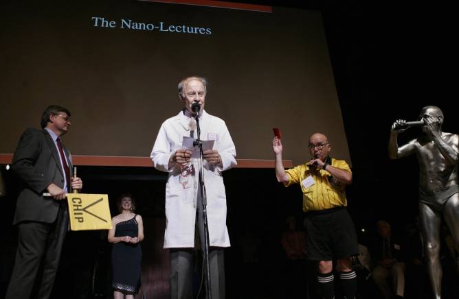 four people on a stage making a presentation