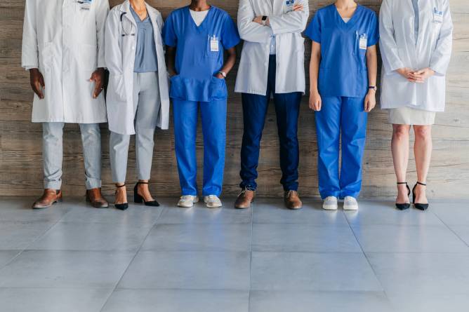 Medical professionals dressed in scrubs are pictured from the waist down.