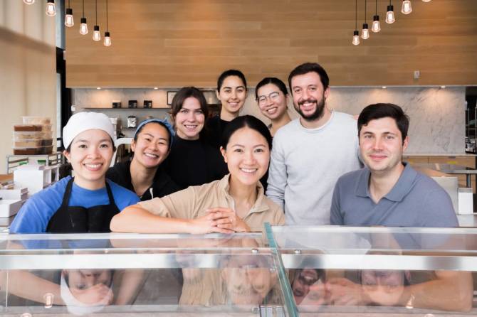 Eight people standing in front of a counter.