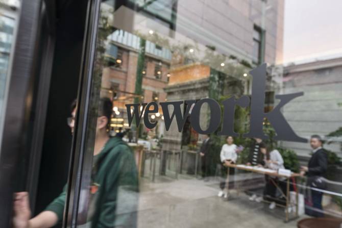 Workers exit a WeWork office