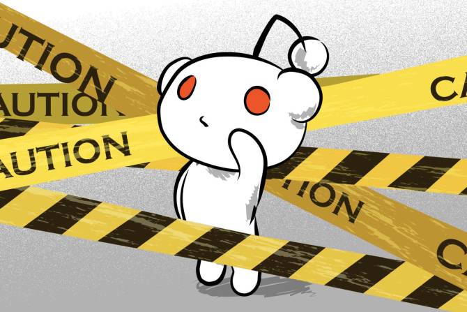 the Reddit mascot Snoo in front of caution tape