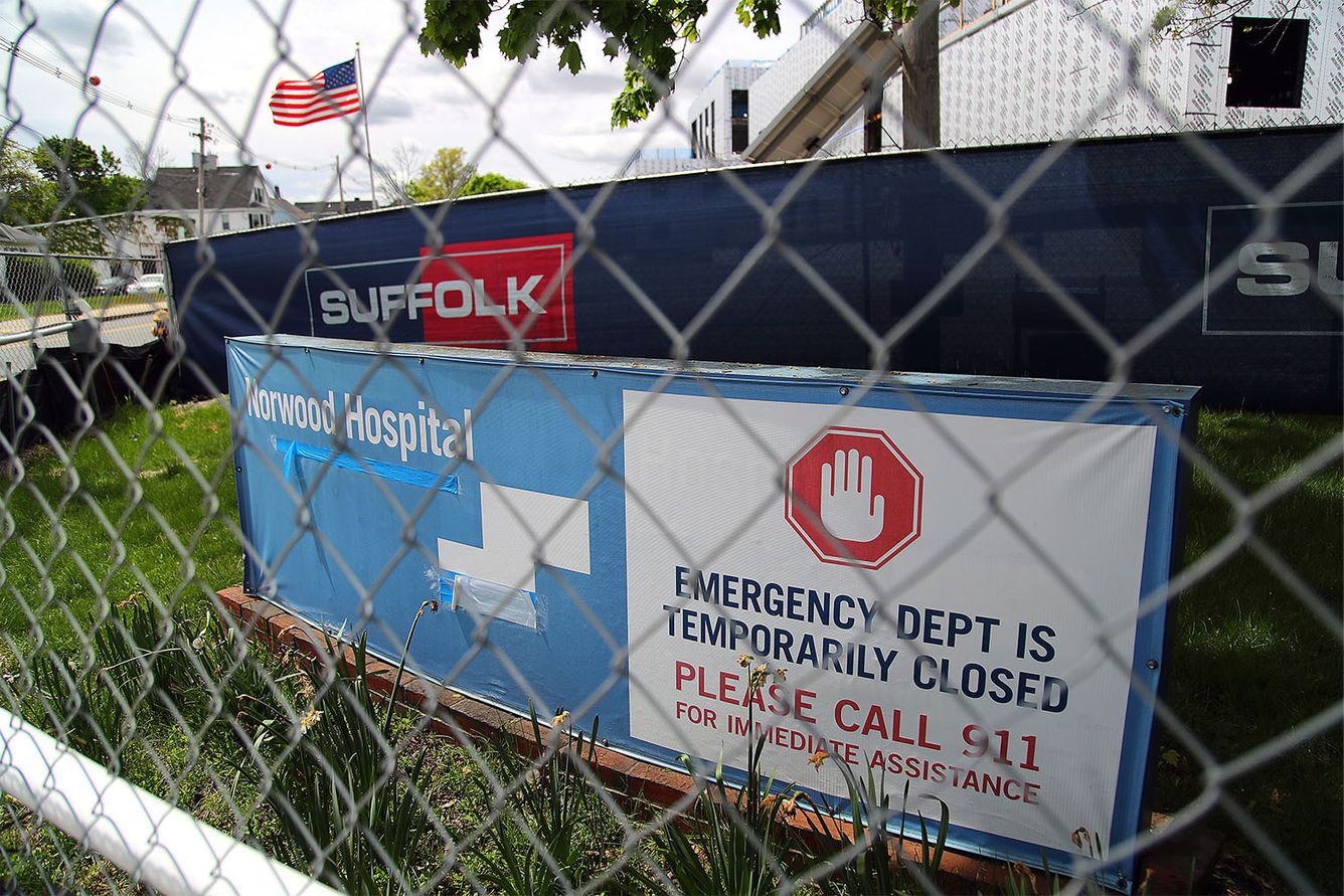 Norwood Hospital sign saying the emergency department is closed behind a fence