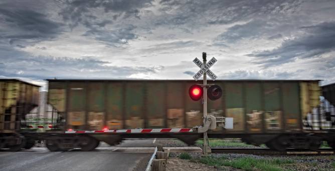 a freight train at a red railroad crossing signal