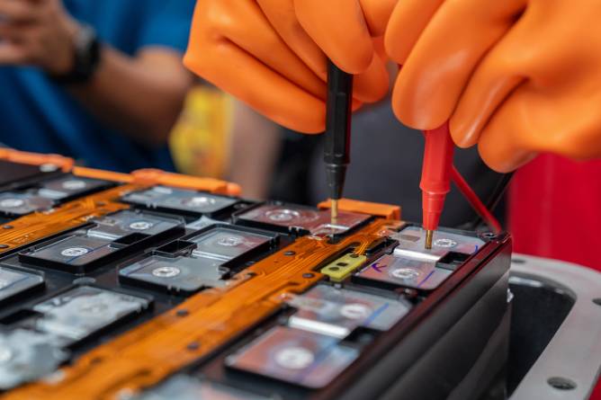 Image of a person working on an EV battery.
