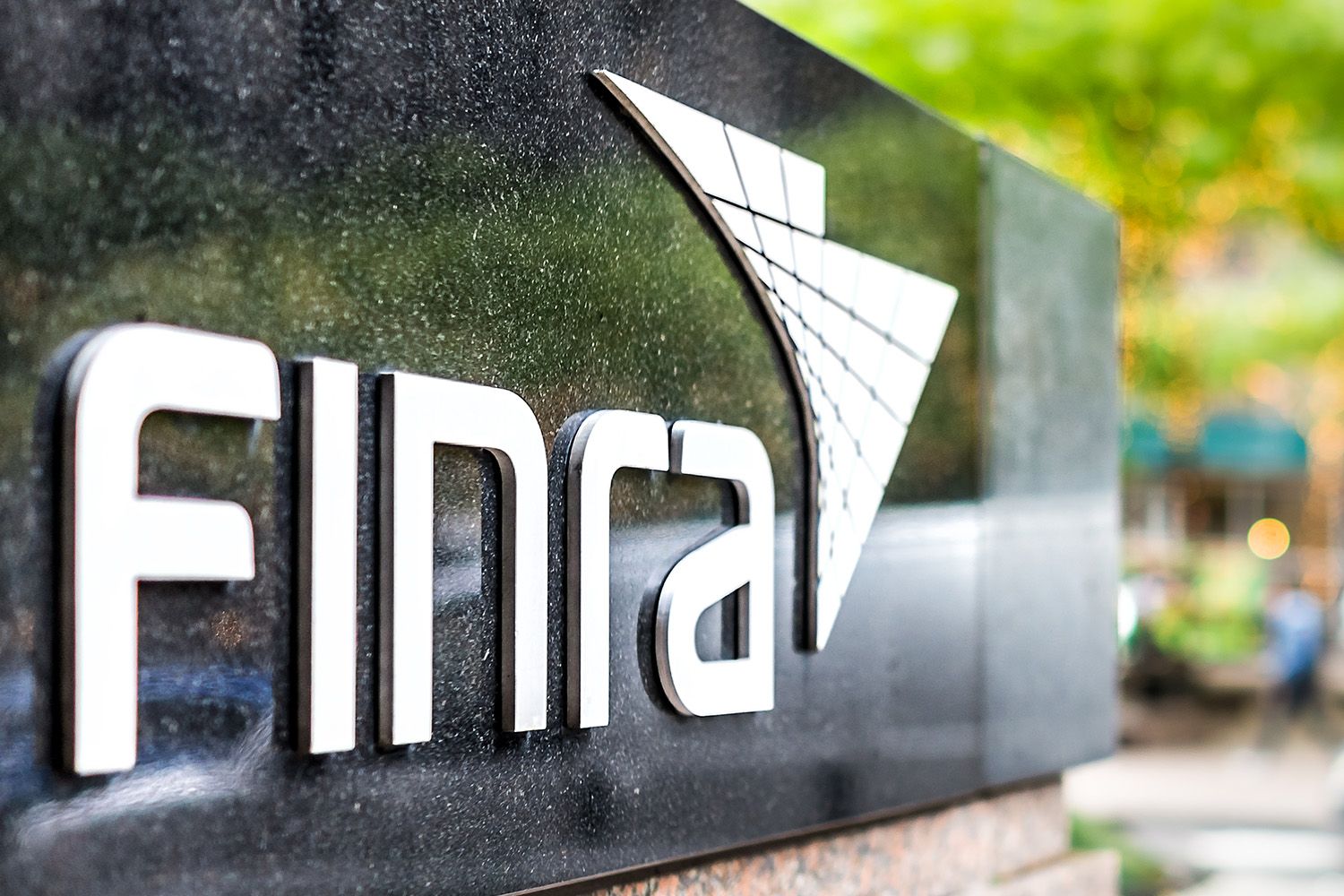 The FINRA logo on a granite sign.