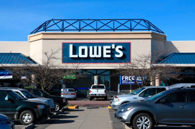 Cars in a parking lot in front of a Lowe’s store.