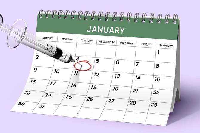 A calendar of January 2022 with a vaccine syringe stuck into January 4