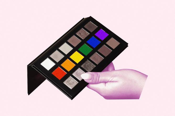 Hand holding eyeshadow palette with pride colors.