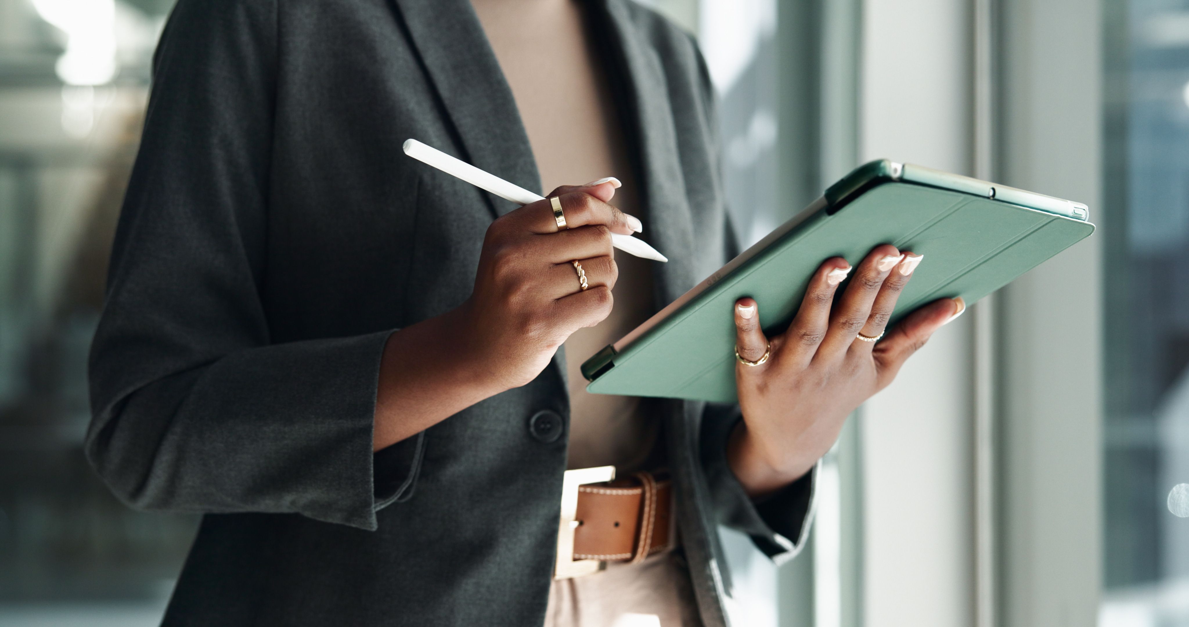 Woman holding a tablet and stylus in her hands.