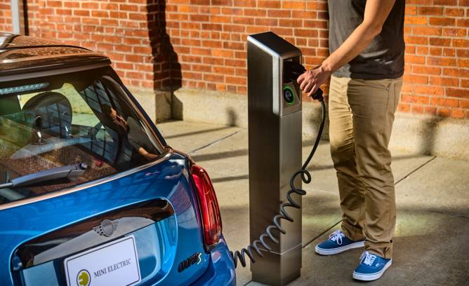 One of Itselectric's curbside charging stations with a vehicle plugged in.