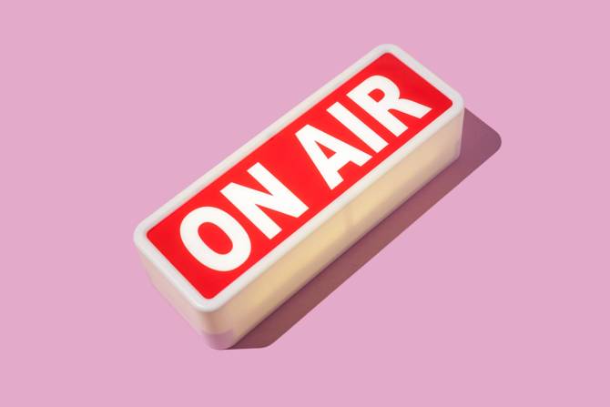 an "ON AIR" sign on a pink background