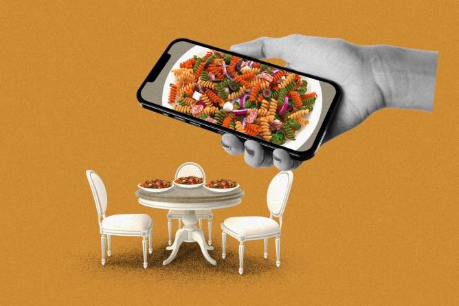 a table with pasta on it with a phone taking a picture above it