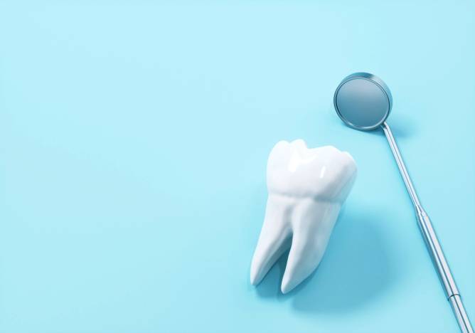 Digital generated image of flat lay tooth with dental mirror on blue background.
