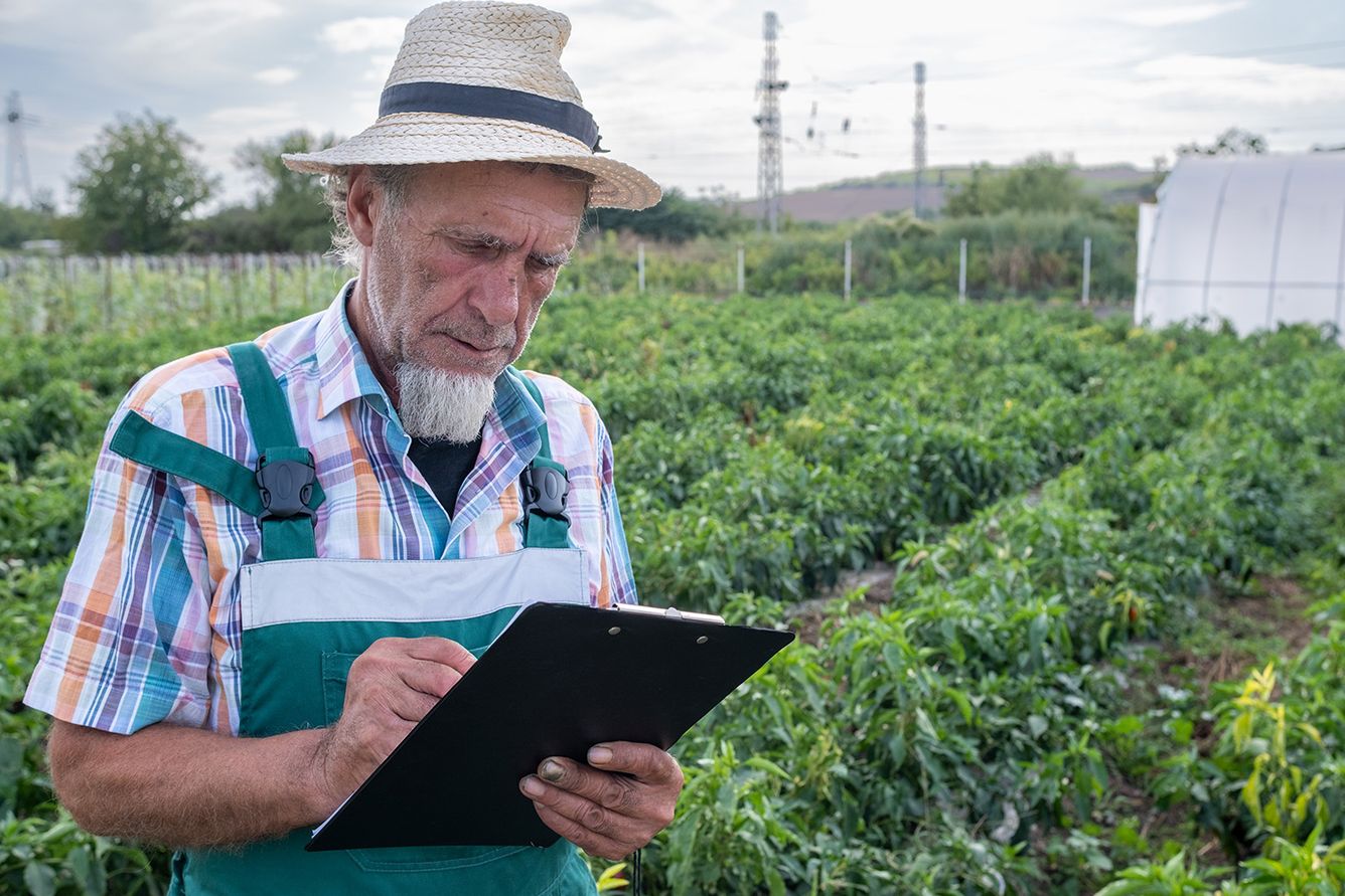 Farmer with a clipboard in hand working on a farm