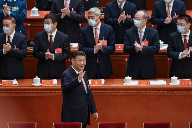 Chinese President Xi Jinping, is applauded as he waves to senior members of the government as he arrives to the Opening Ceremony of the 20th National Congress