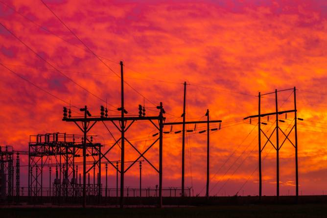 Fiery sunset with a power station collection grid silhouetted