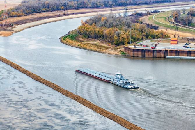 A tugboat pushing a barge up into a canal controlled by locks along the Mississippi River just north of the city of St. Louis.