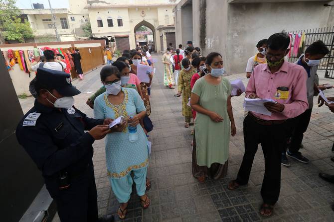 Candidates stand in line before taking the Rajasthan Eligibility Exam for Teachers