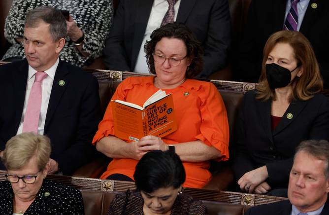 U.S. Rep.-elect Katie Porter (D-CA) reads a book in the House Chamber during the fourth day of elections for Speaker of the House.